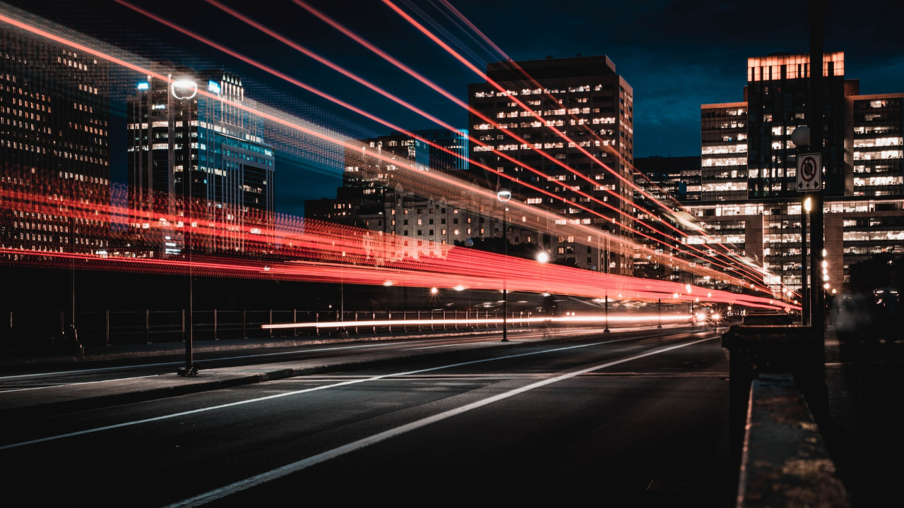 Fast red lights travelling through the city at night | Internet Fiber Optics